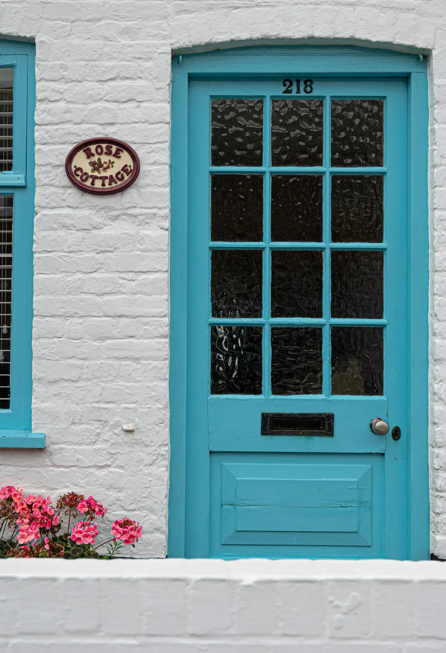 a blue door and window on a white brick building