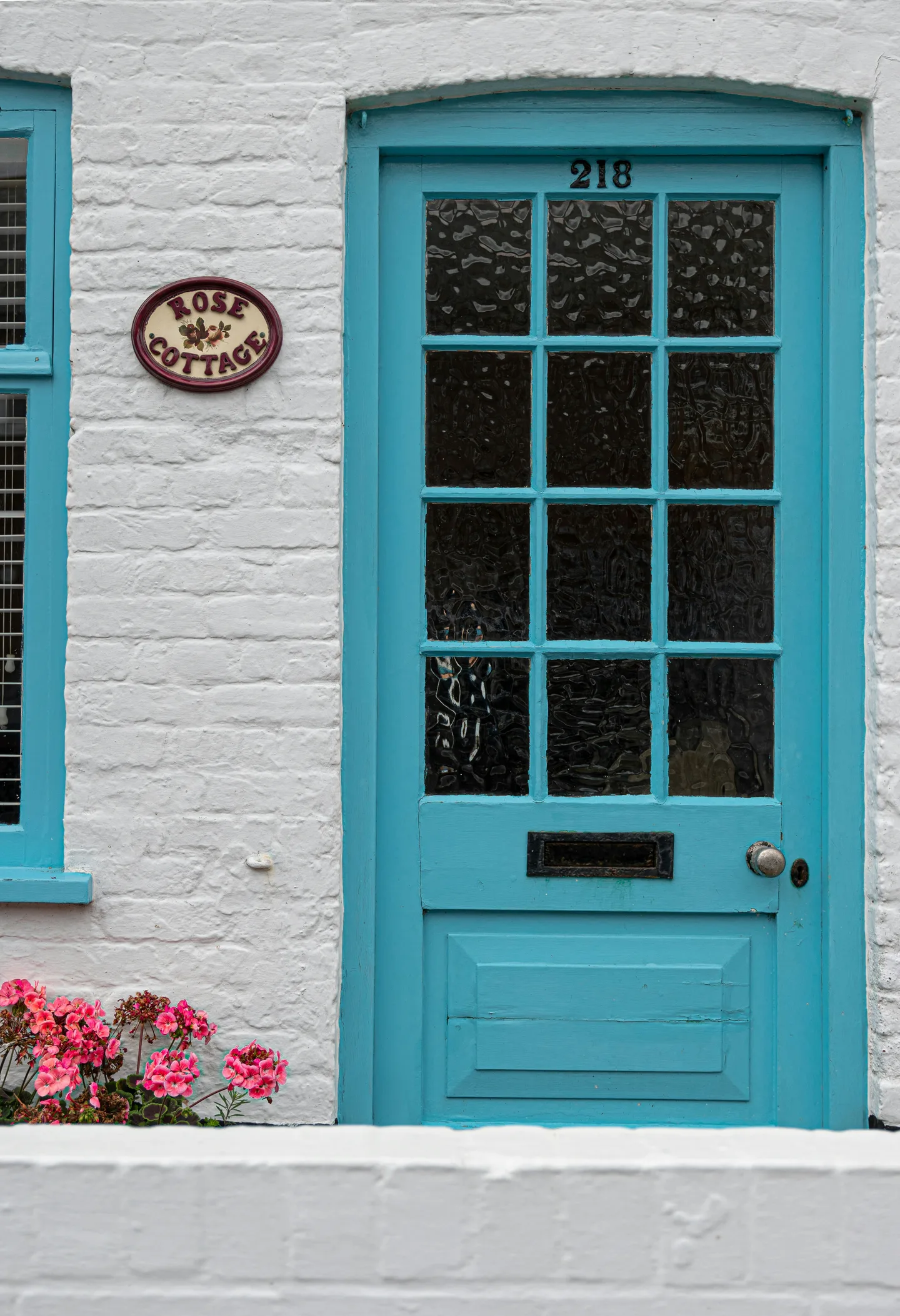 a blue door and window on a white brick building